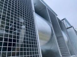 A close up of a metal grille on the side of a building.