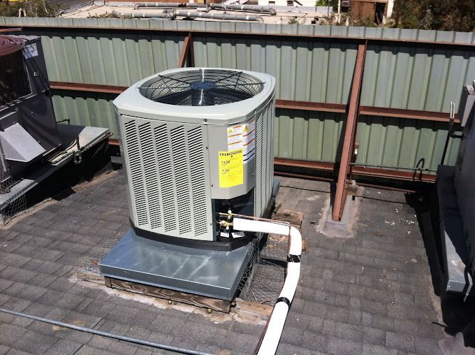 A large air conditioner is sitting on top of a roof.