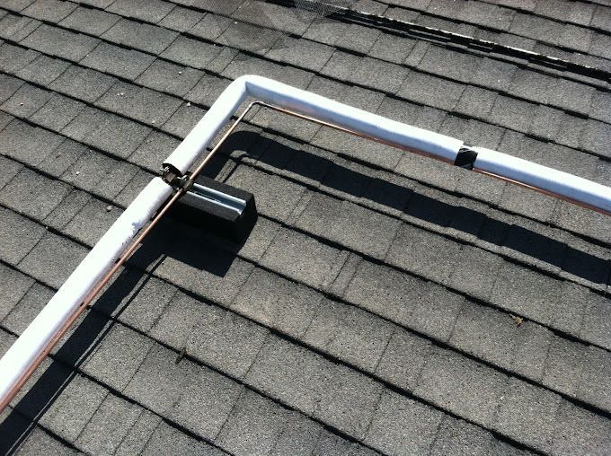 A white pipe is sitting on top of a roof