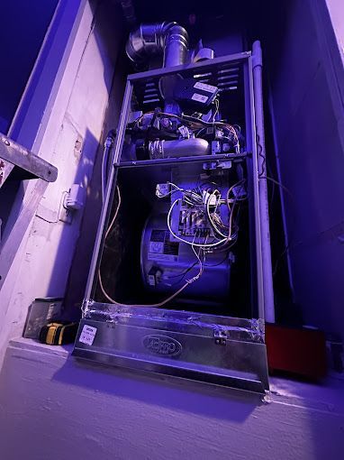The inside of a heating system with a blue light shining on it.