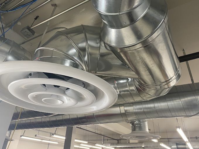 A room with a lot of metal pipes hanging from the ceiling.