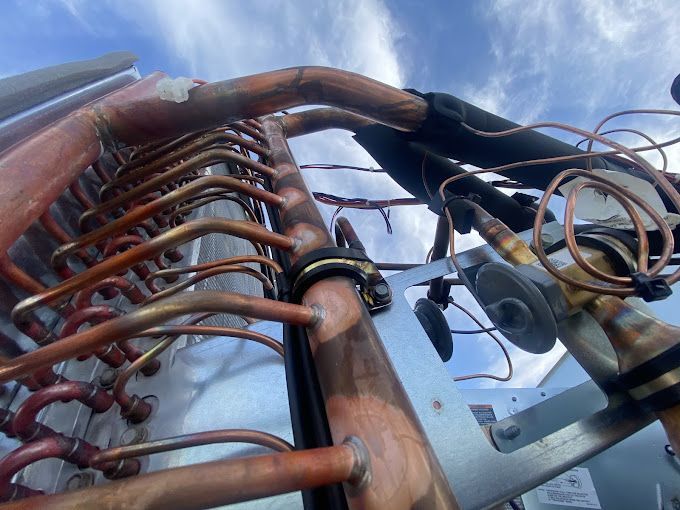 A bunch of copper pipes are connected to a machine.