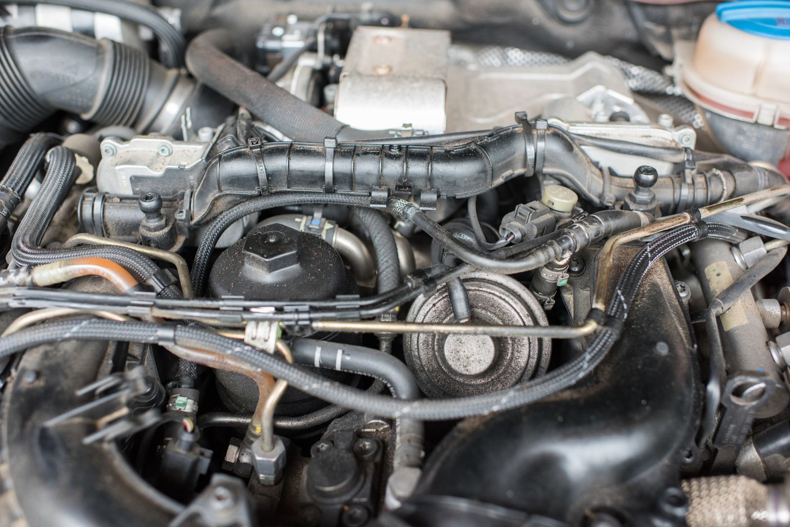 A close up of a car engine with a lot of wires coming out of it.