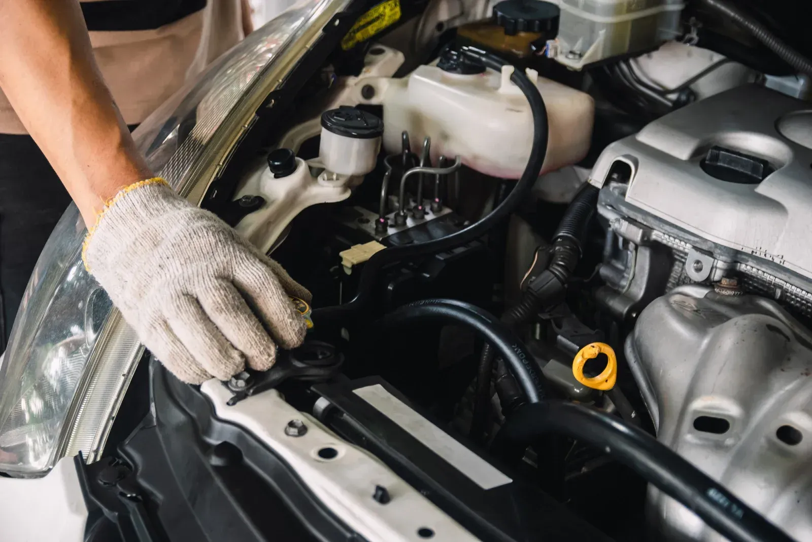 A man is working on the engine of a car.