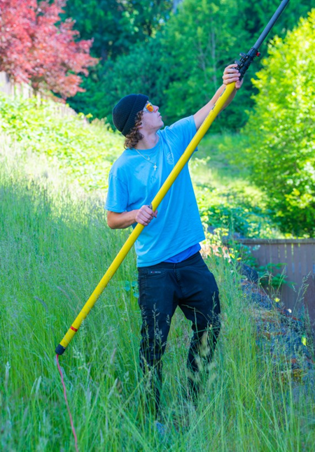 Professional residential window cleaning service by a worker using a squeegee and microfiber cloth.
