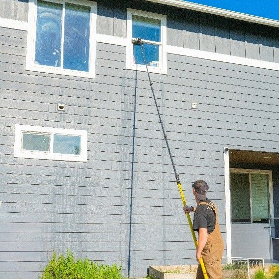 Window cleaning service specialist using advanced equipment to clean residential windows. Window cleaning service specialist using advanced equipment to clean residential windows.