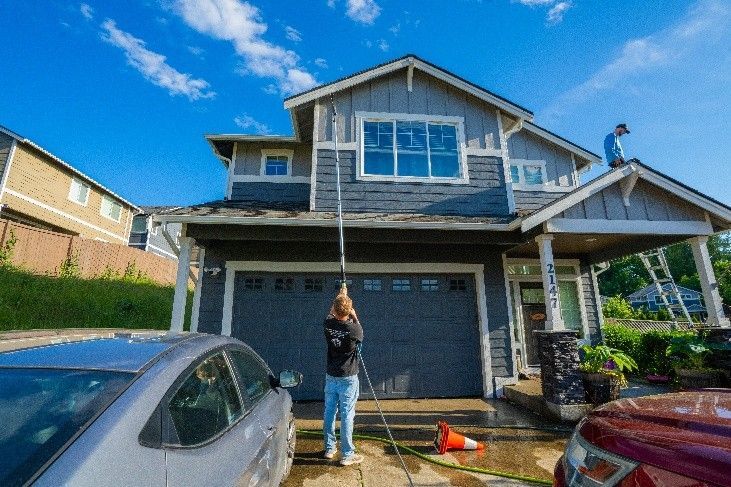 Specialist using a water-fed pole to rinse second-story windows. Specialist using a water-fed pole to rinse second-story windows.