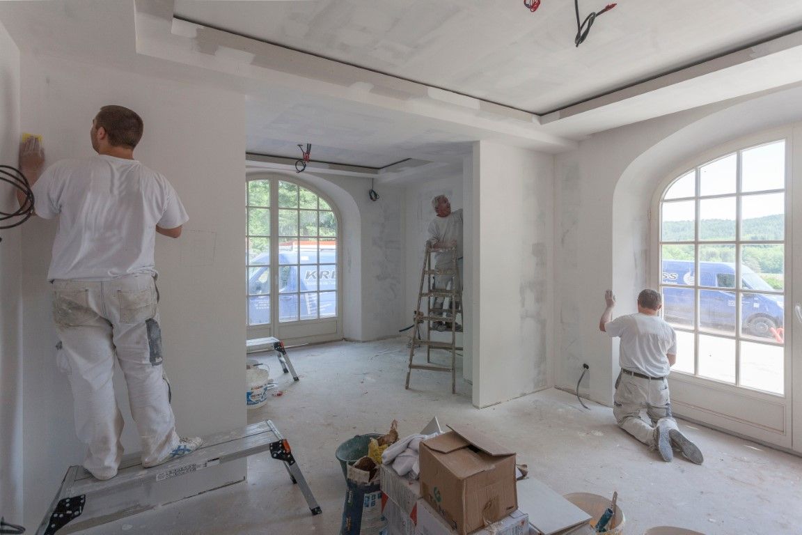 Two workers are busy scrubbing the walls to remove the paint.