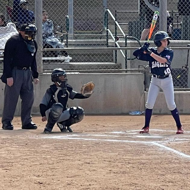 Baseball player sliding into home plate, catcher in front. Blue and gold uniforms, action shot.