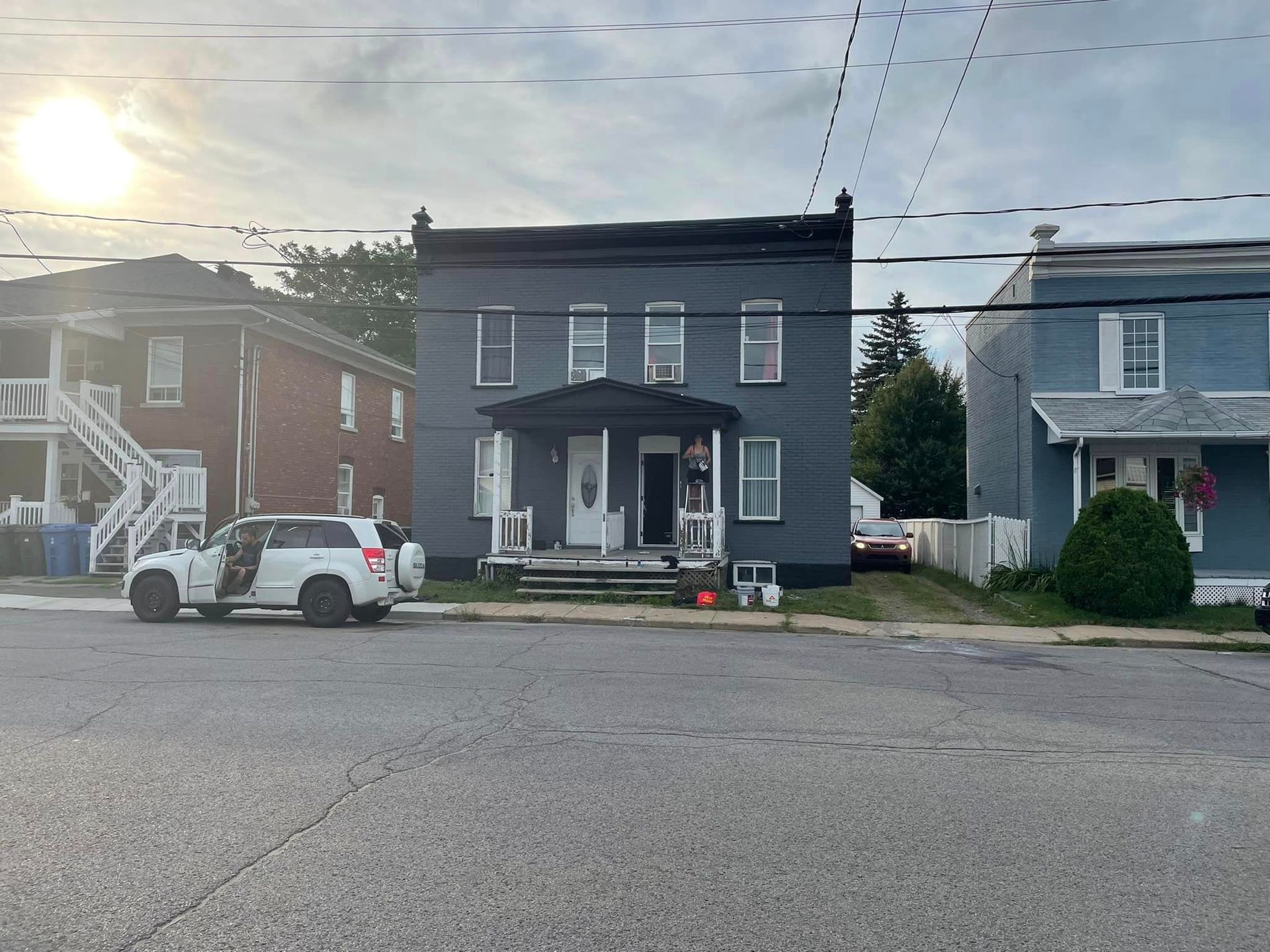 Un SUV blanc est garé devant un grand bâtiment.