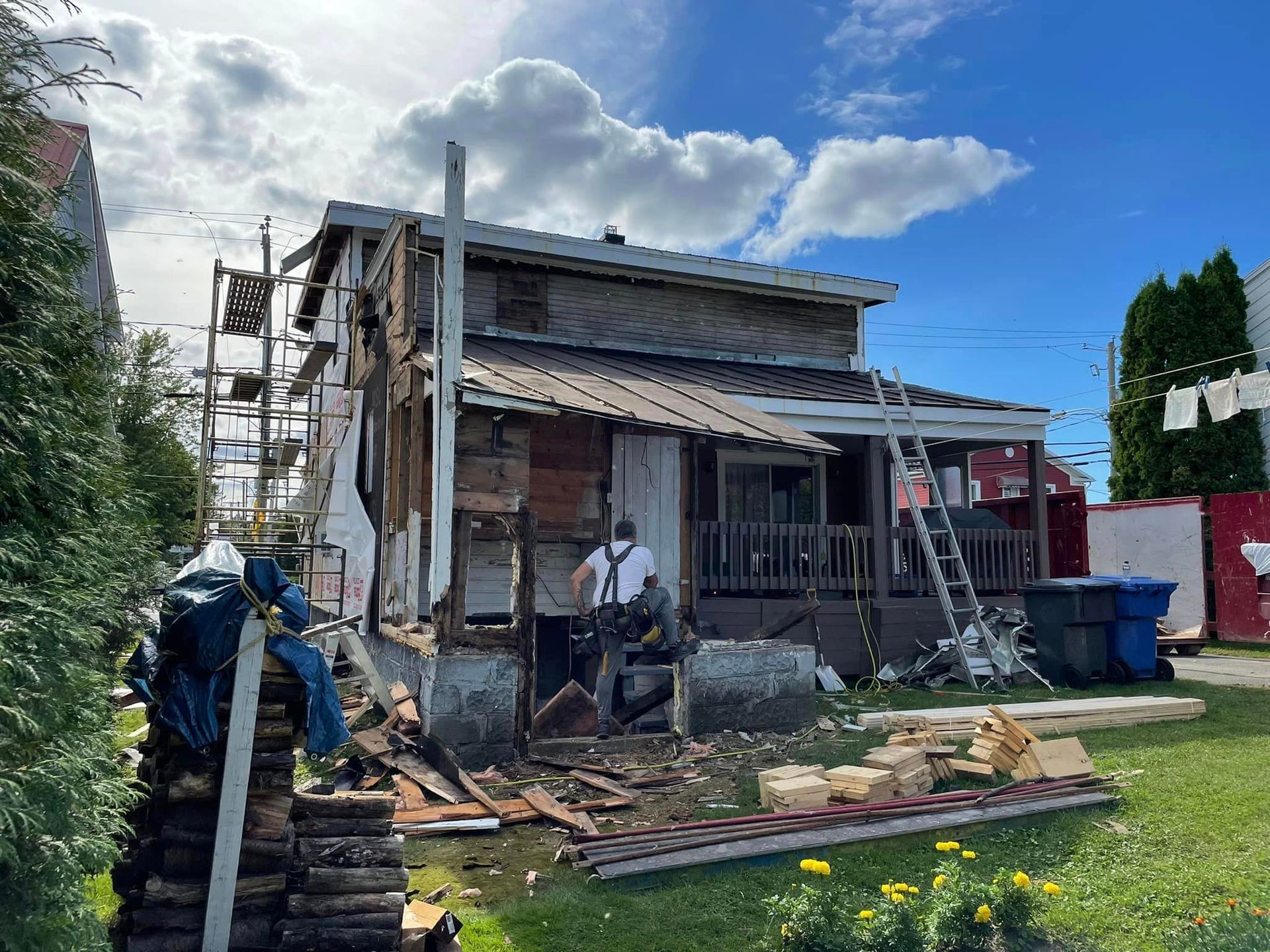 Un homme se tient devant une maison en cours de démolition.
