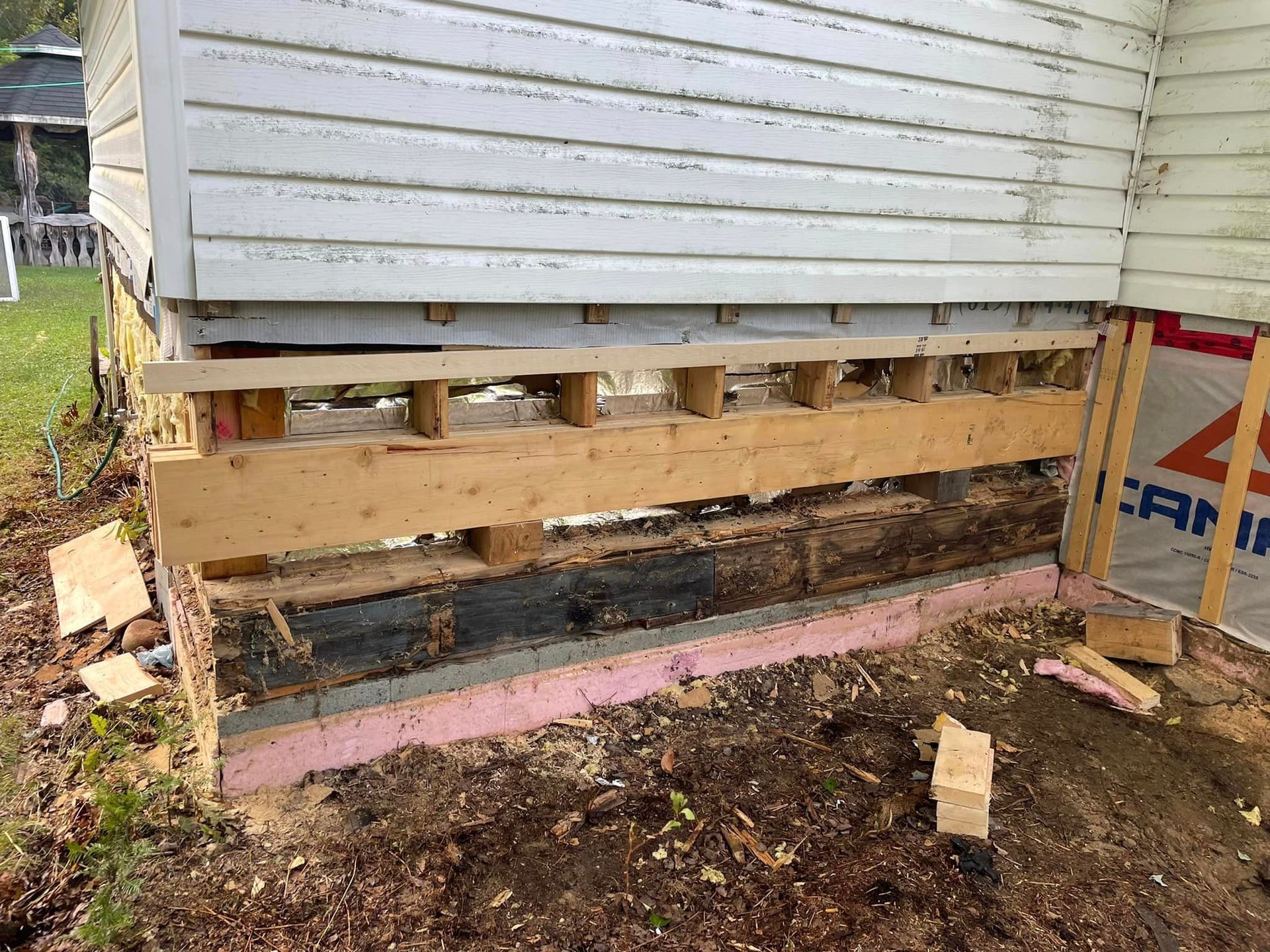Une structure en bois est en cours de construction autour d'une maison.
