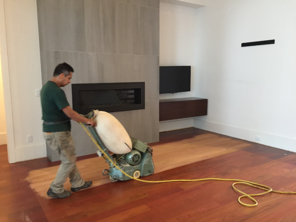Technician sanding hardwood floors as part of the refinishing process.  Home located in Toledo, OH