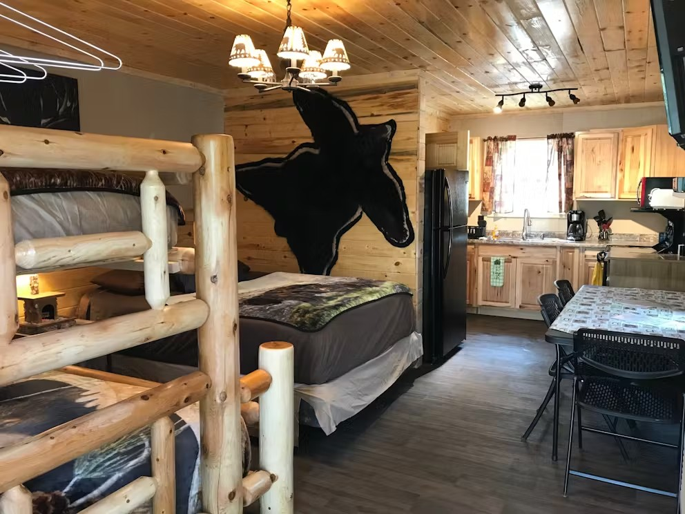 A bedroom in a log cabin with bunk beds and a horse on the wall.