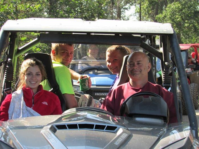 A group of people are sitting in a honda atv