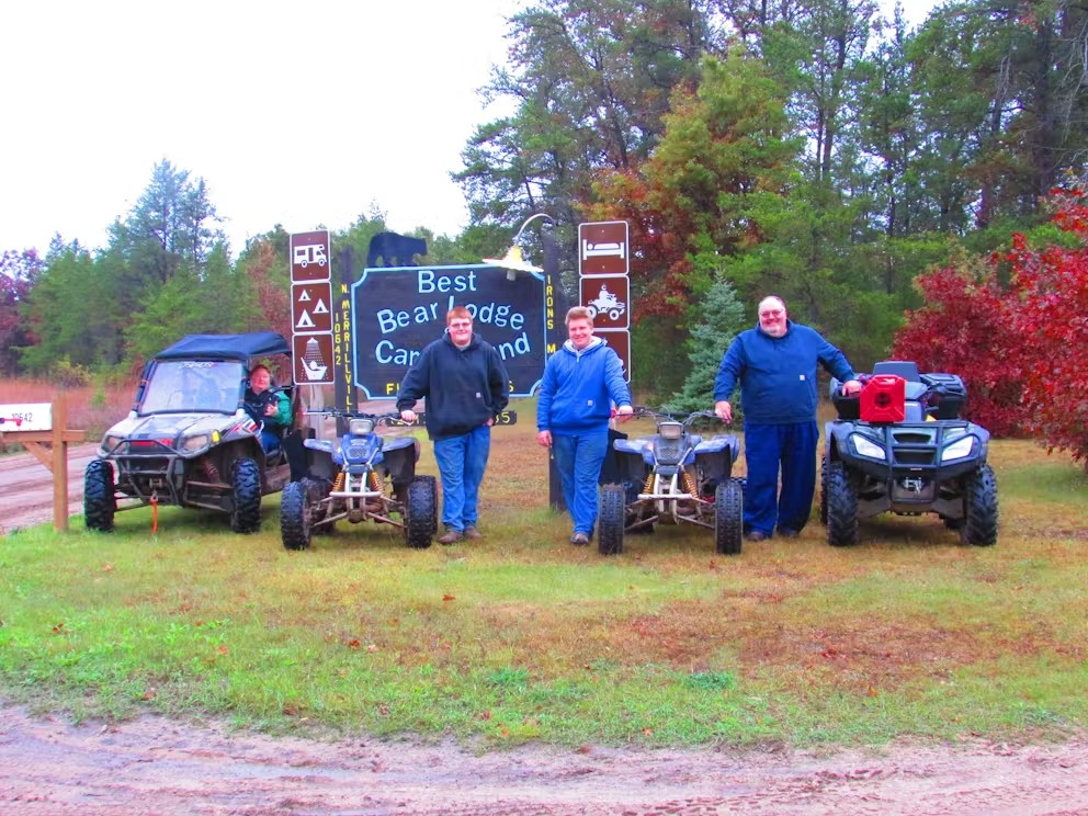 A group of people standing in front of a sign that says best season camp