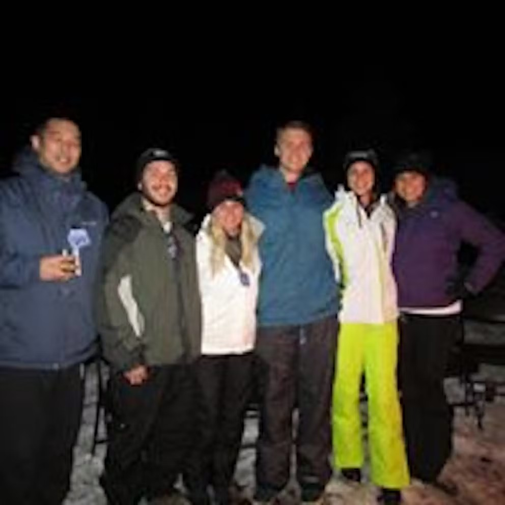 A group of people are posing for a picture in the snow.