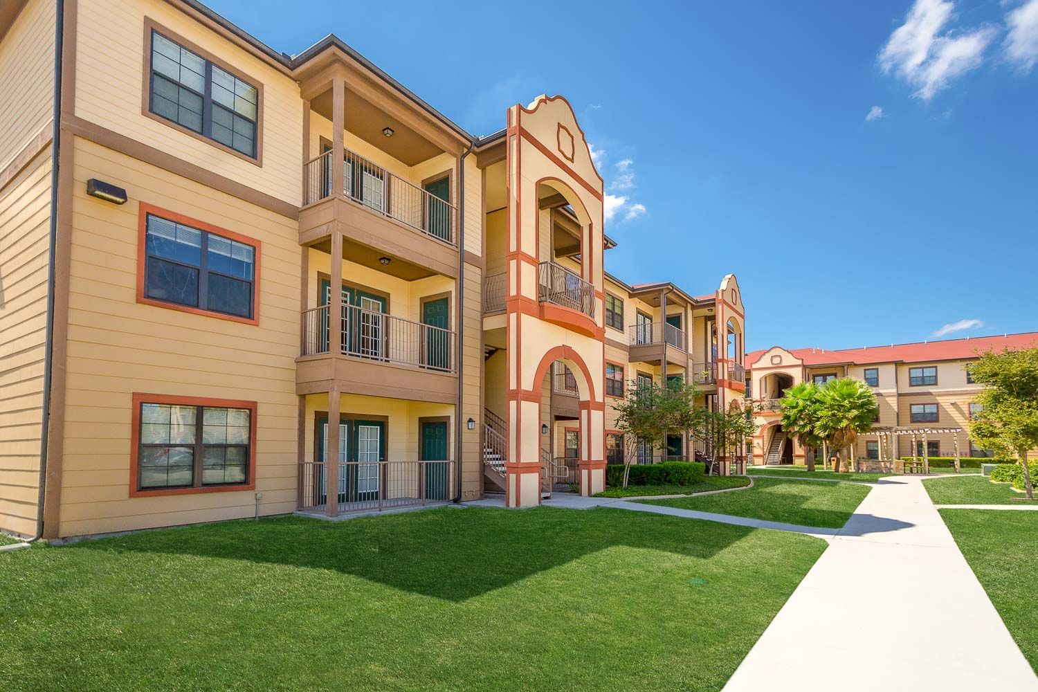 A large apartment building with a walkway leading to it.