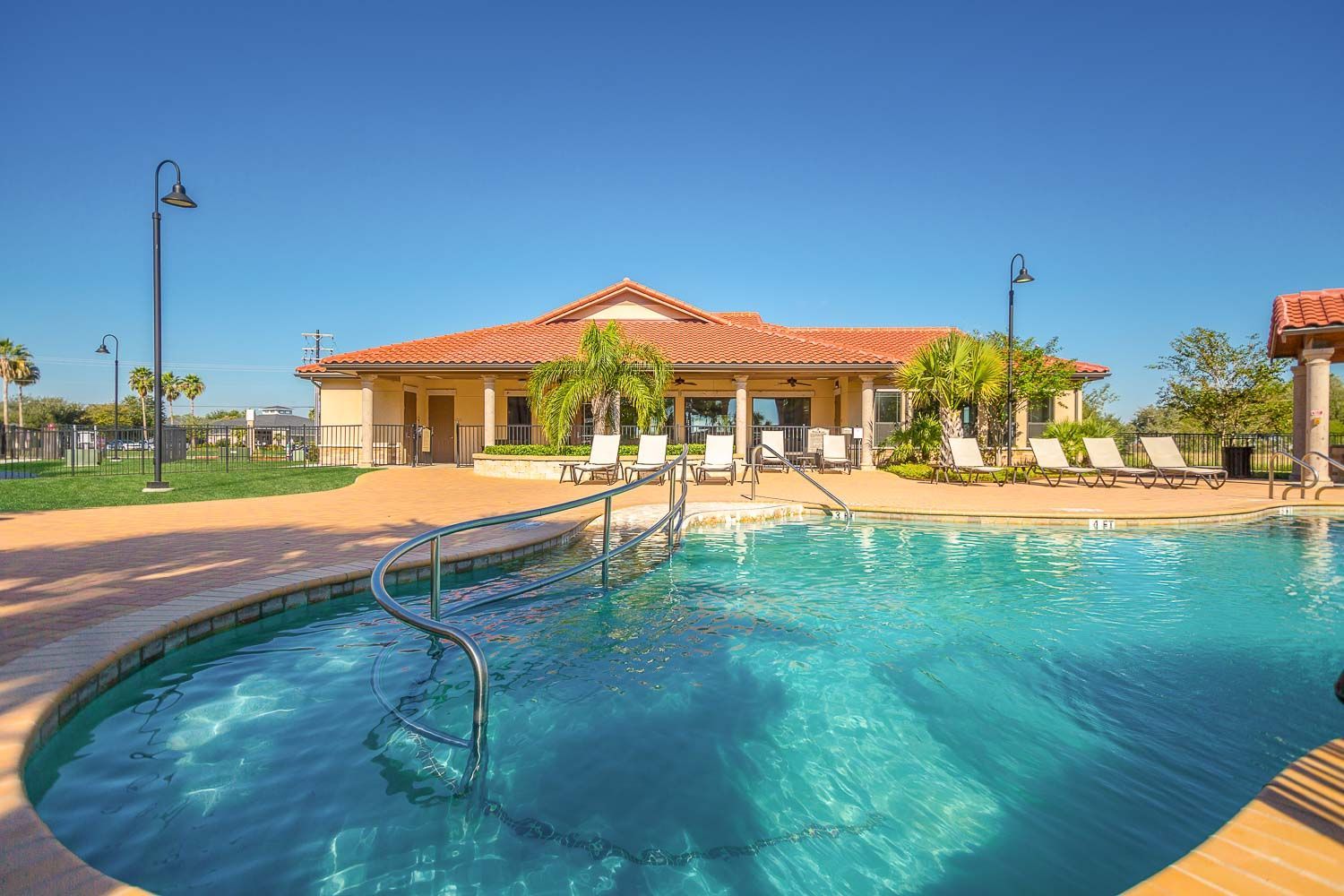 There is a large swimming pool in front of a house.