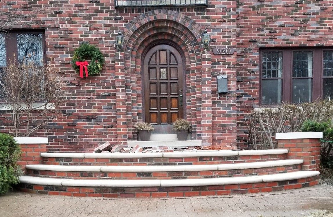 A brick house with a wooden door and steps