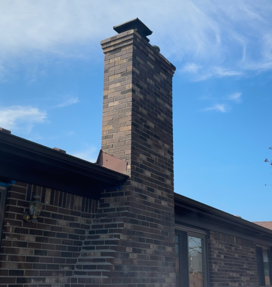 A brick chimney on the side of a house