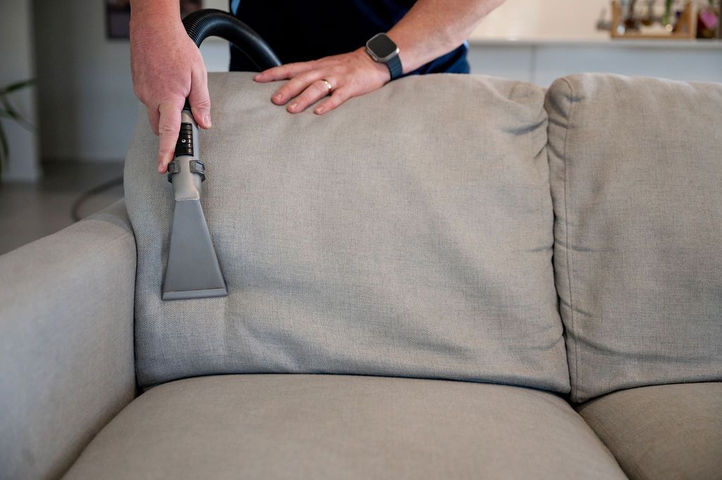 lounge cleaning man cleaning a grey lounge in a home