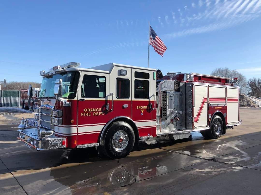 A red and white fire truck is parked on the side of the road.
