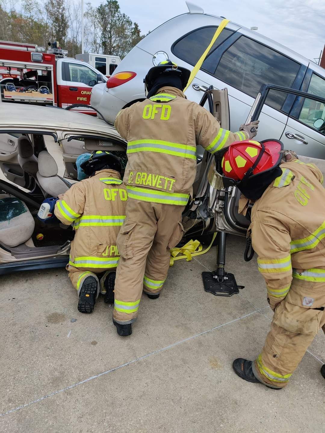 A group of firefighters are working on a car accident.