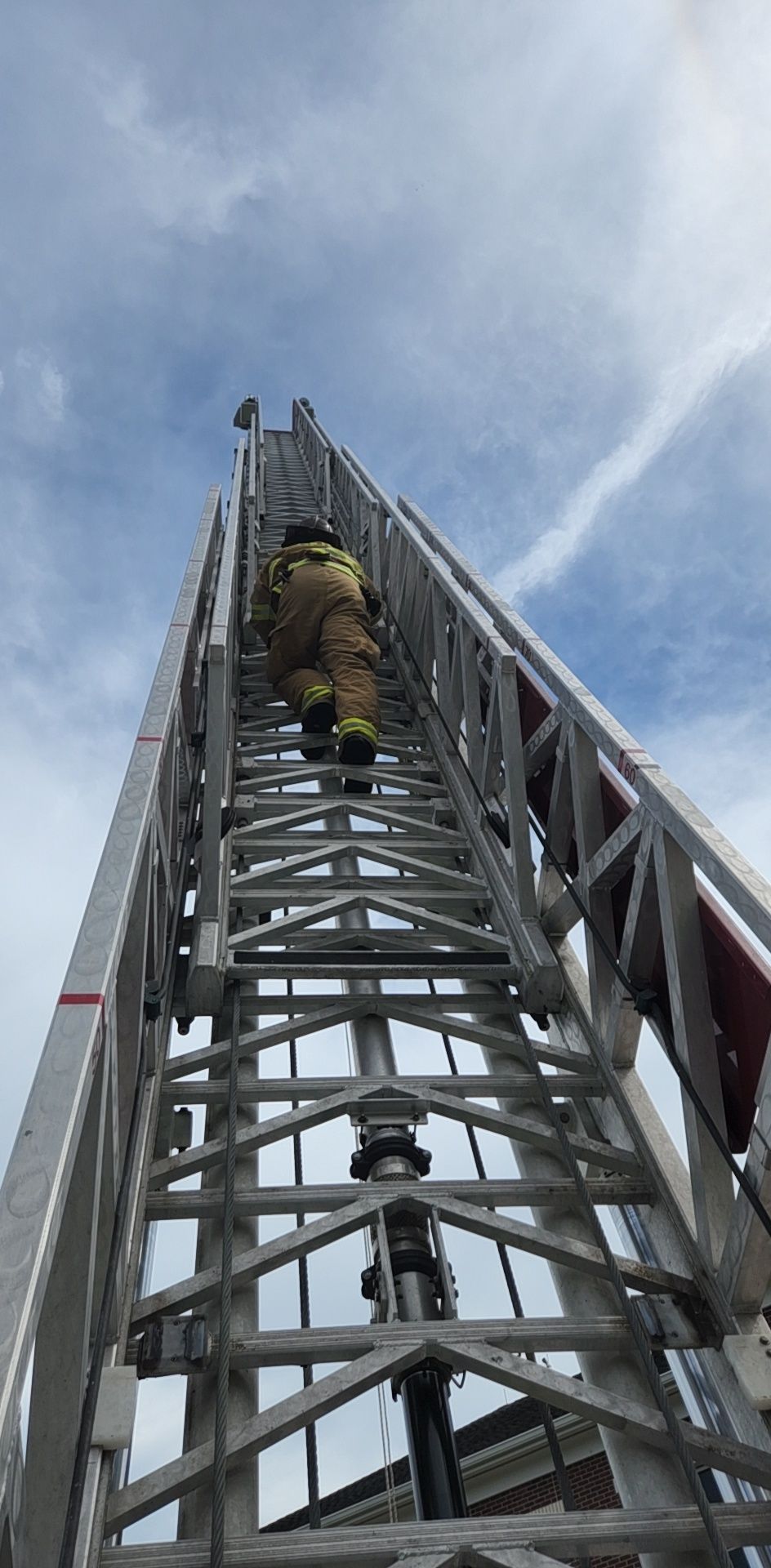 A firefighter is climbing up a ladder.