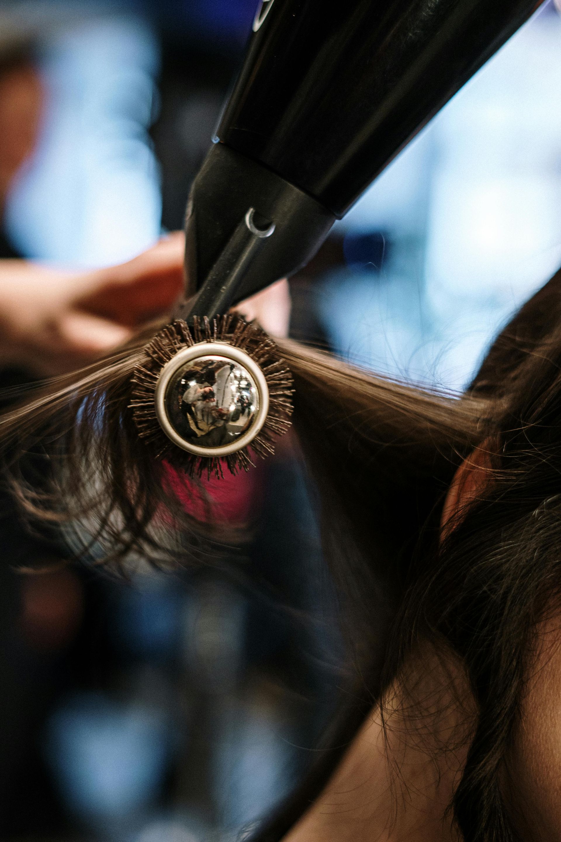 A woman with long blonde hair is sitting in a chair in a salon.
