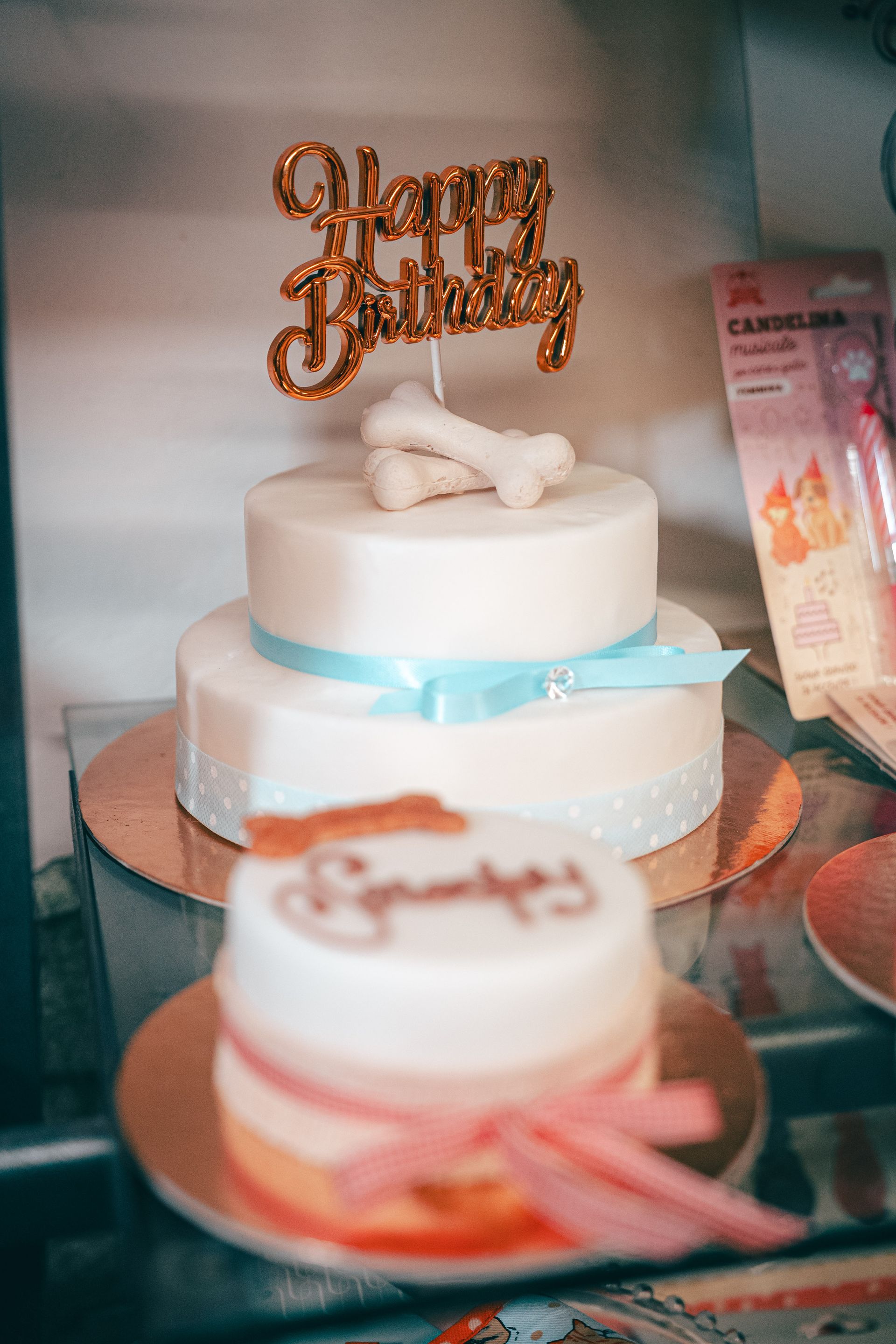 Torta bianca a due piani con topper con la scritta 