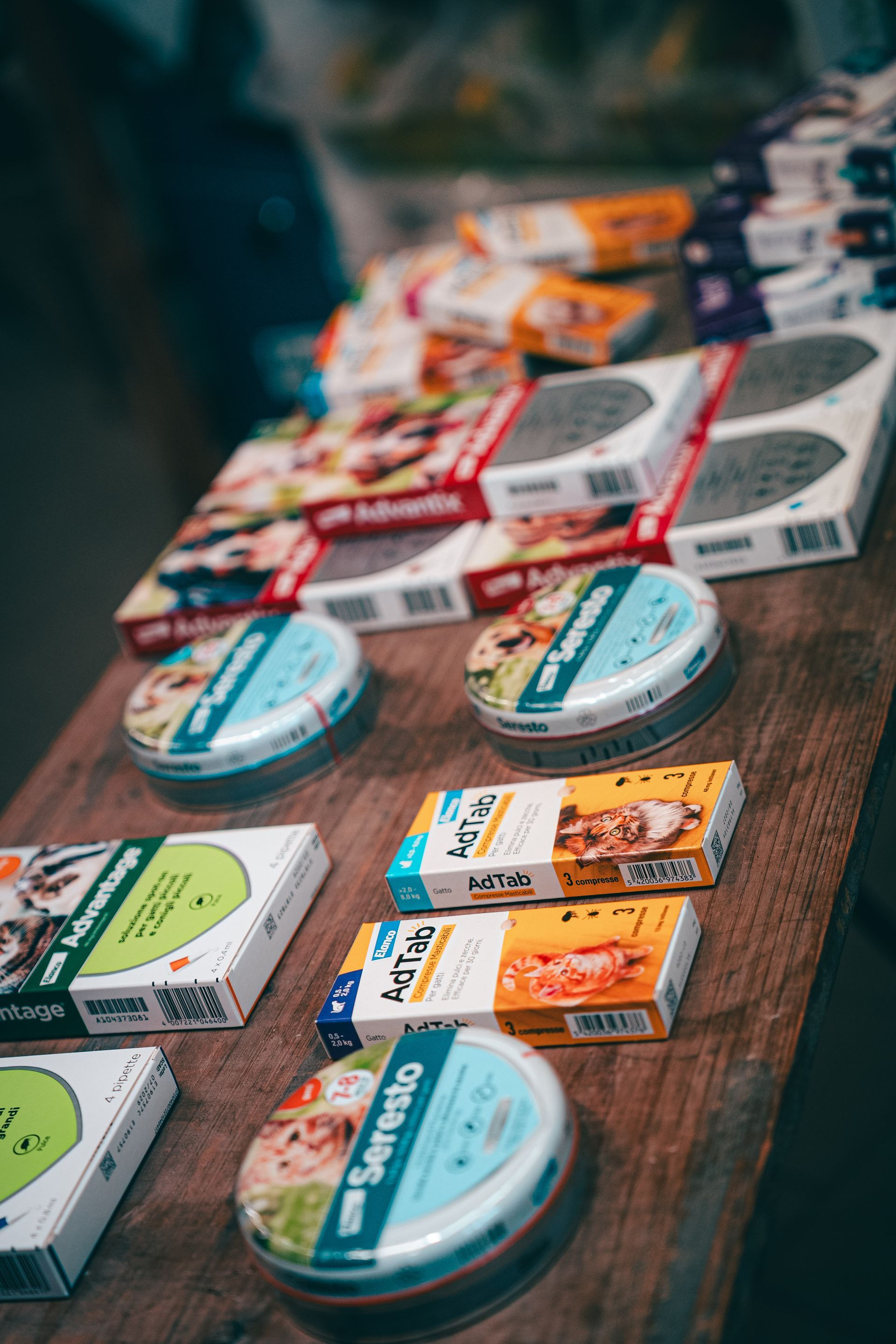 Prodotti alimentari in scatola e in scatola su una superficie di legno, con diverse marche e gusti visibili.