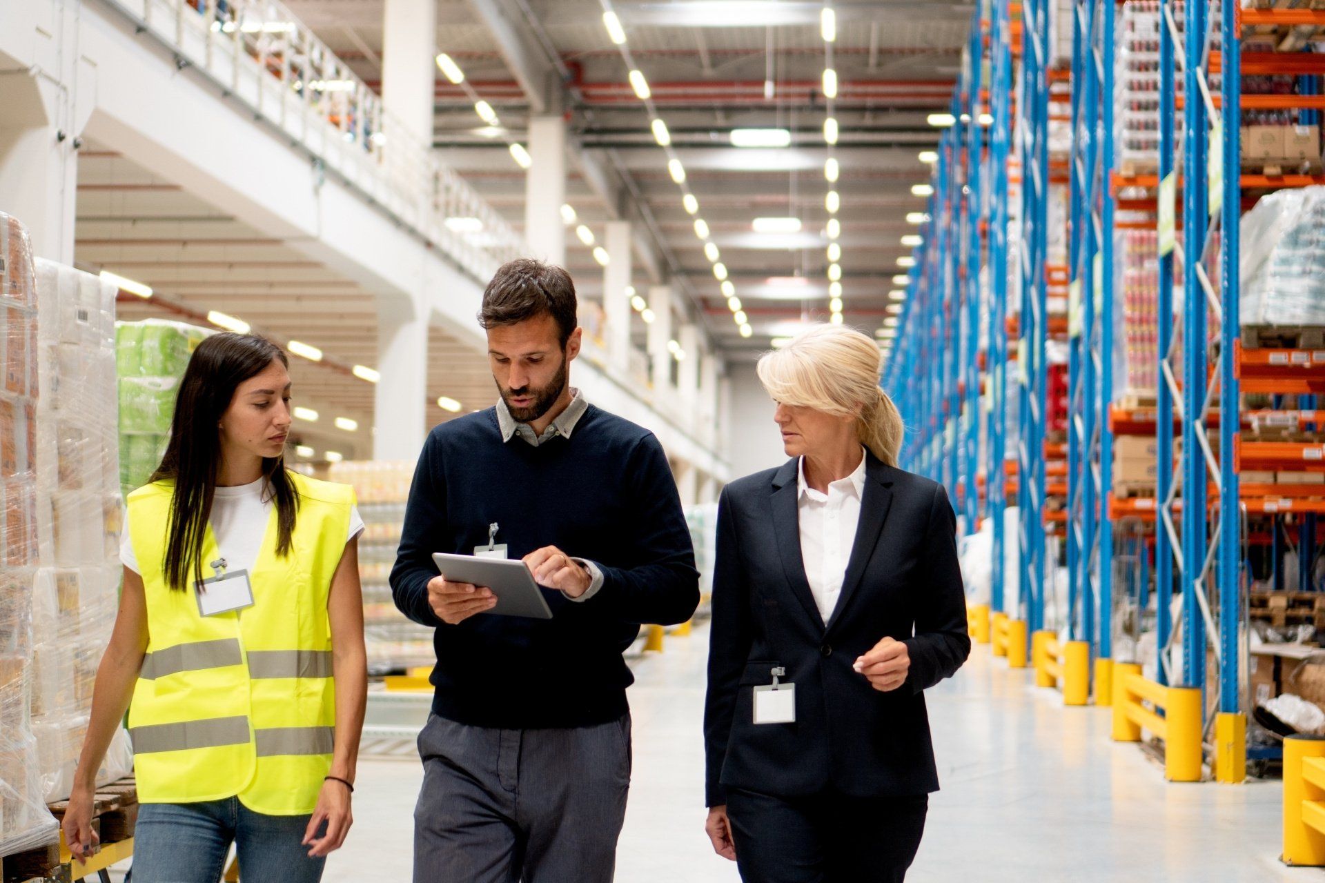 A group of people are walking through a large warehouse.