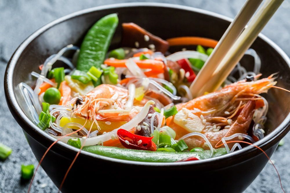 A Bowl of Shrimp and Vegetables With Chopsticks in It — One Thai Cuisine & Noodle Bar In Kirwan, QLD