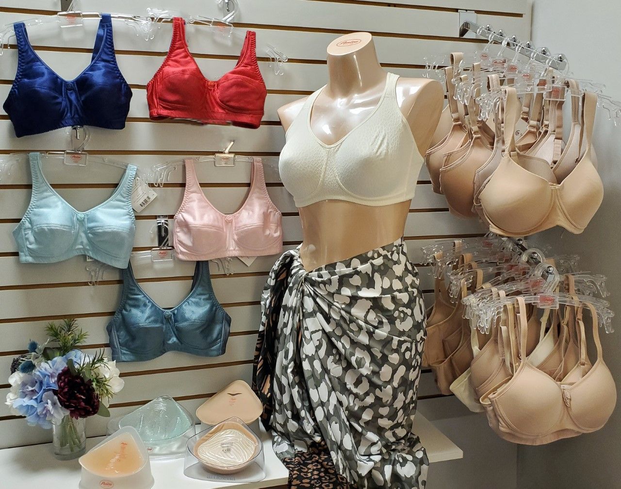 Bras on display in various colors, mannequin wearing a bra and sarong.