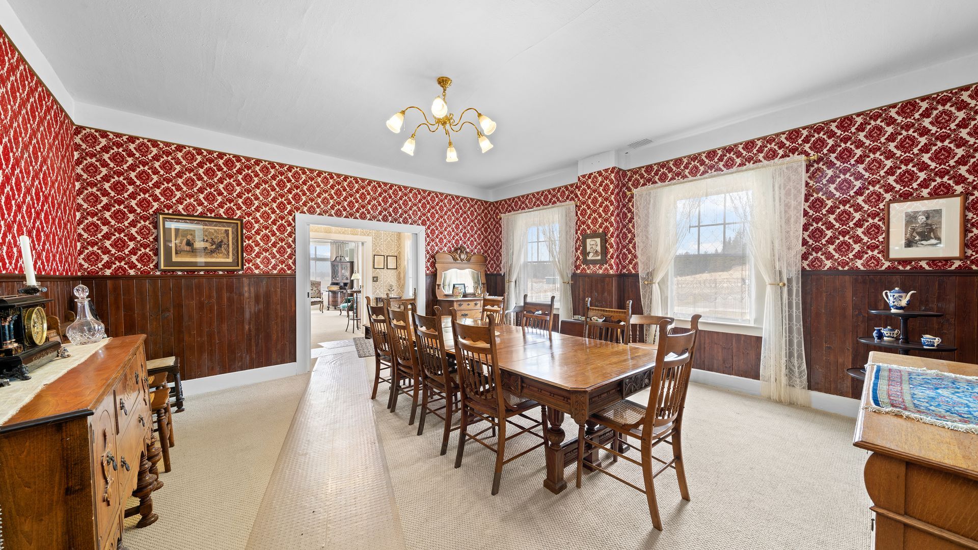 A large dining room with a long wooden table and chairs.