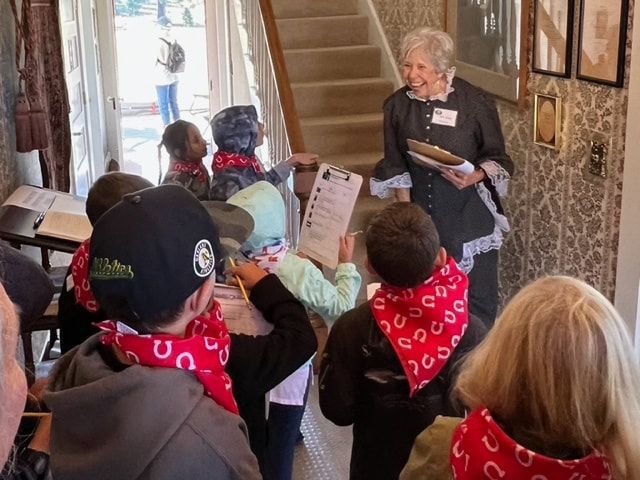 A woman is giving a presentation to a group of children