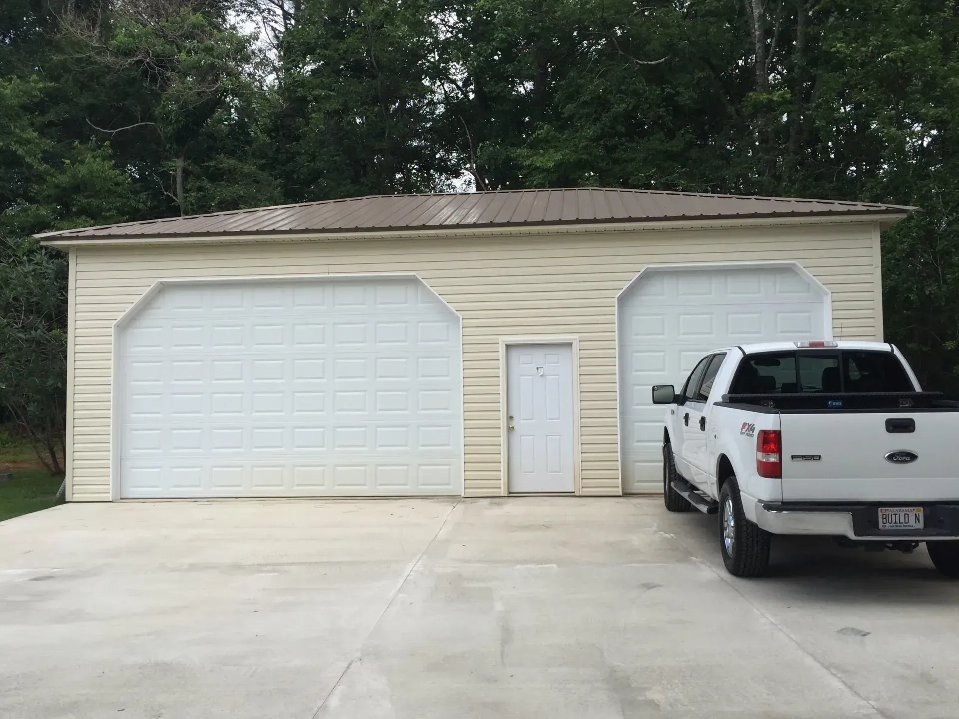 a white truck is parked in front of a garage