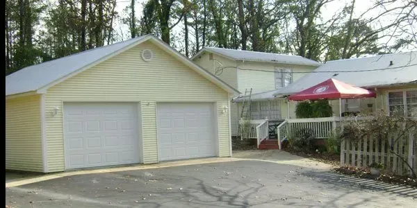 a house with a garage and a red umbrella in front of it