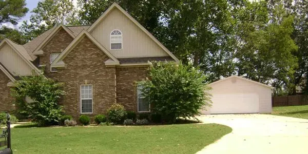 a large brick house with a white garage and a driveway