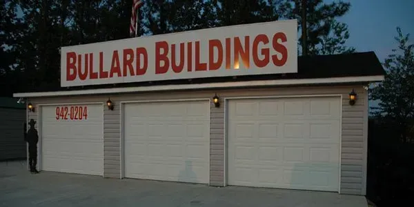 a building with three garage doors and a sign that says bullard buildings