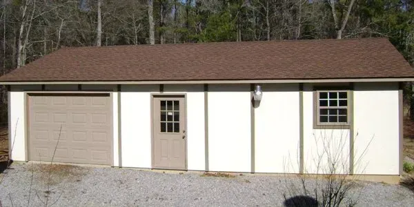 a small white garage with a brown roof