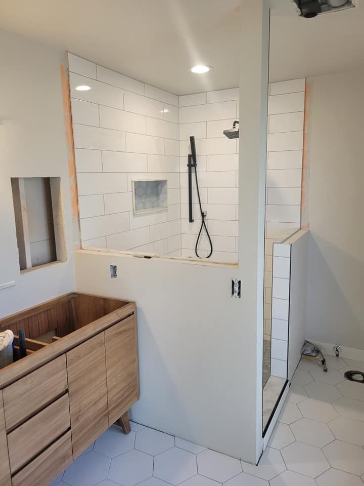 A bathroom with a walk in shower and a sink.
