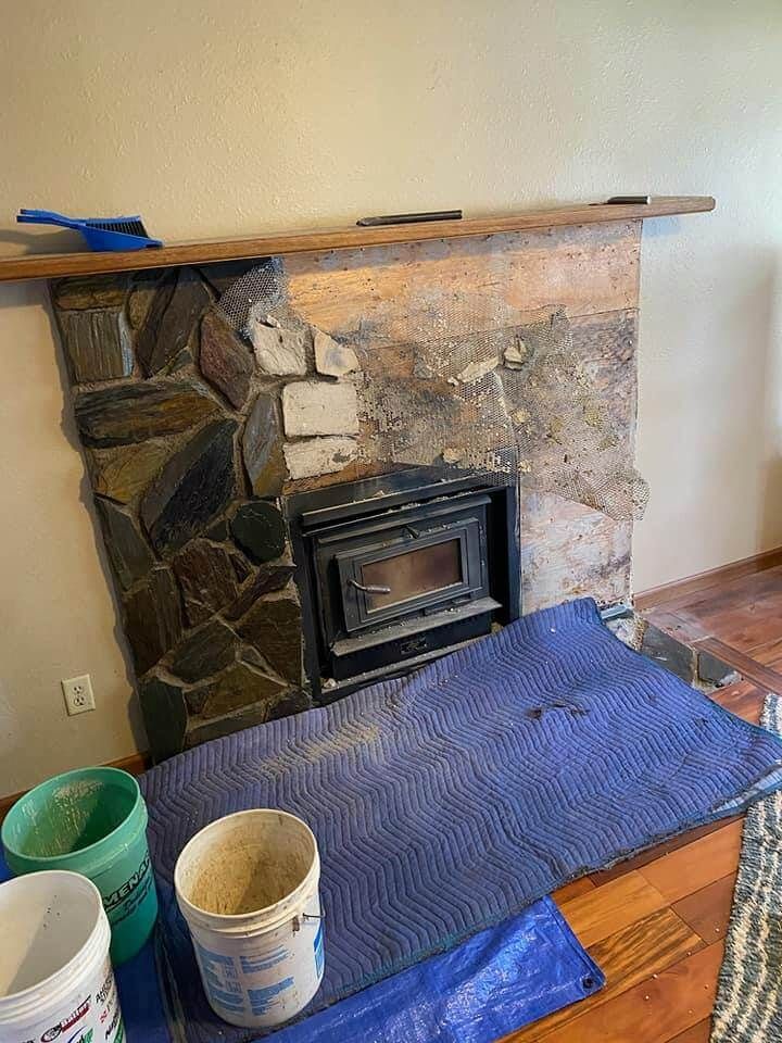 A fireplace is being remodeled in a living room.