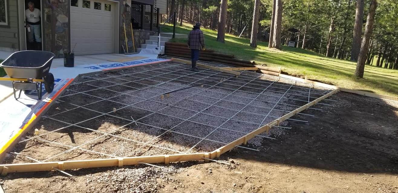 A concrete driveway is being built in front of a house.