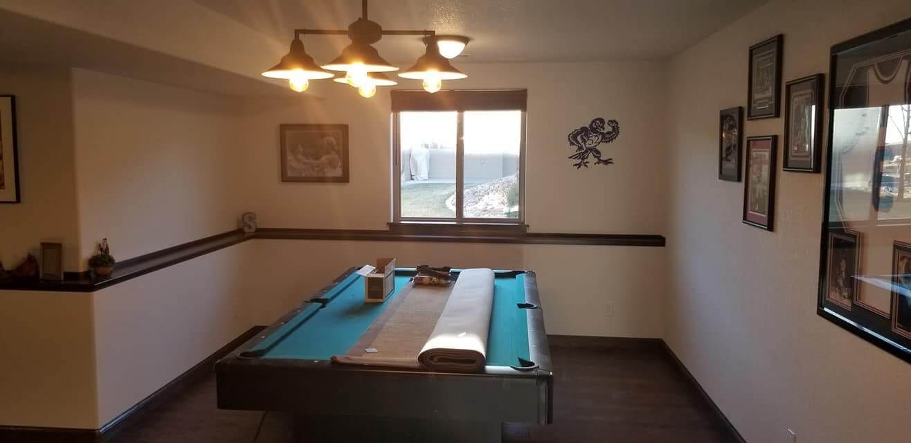 There is a pool table in the middle of the room.