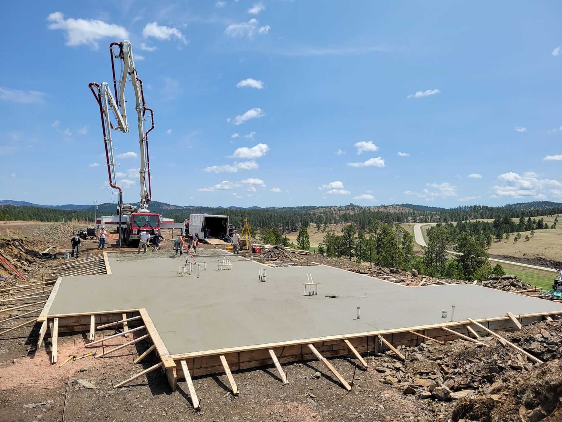 A concrete pump is being used to pour a foundation for a house.