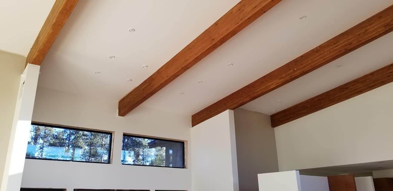 A living room with a wooden ceiling and a lot of windows.