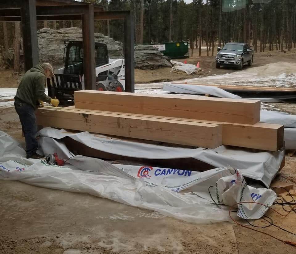 A man is working on a stack of canton lumber