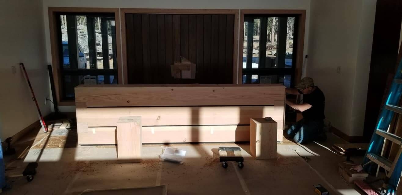 A man is working on a wooden table in a room.